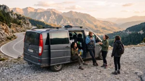 Friends on a stop with the van on a mountain road, with coffee and a view of the valley