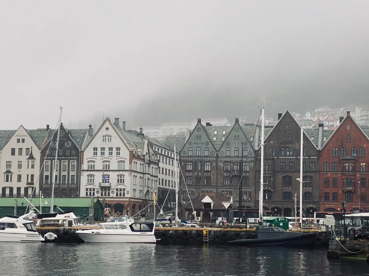 Το Bryggen στο Μπέργκεν στη Νορβηγία, ιστορικά ξύλινα κτίρια και σκάφη στο λιμάνι μέσα στην ομίχλη