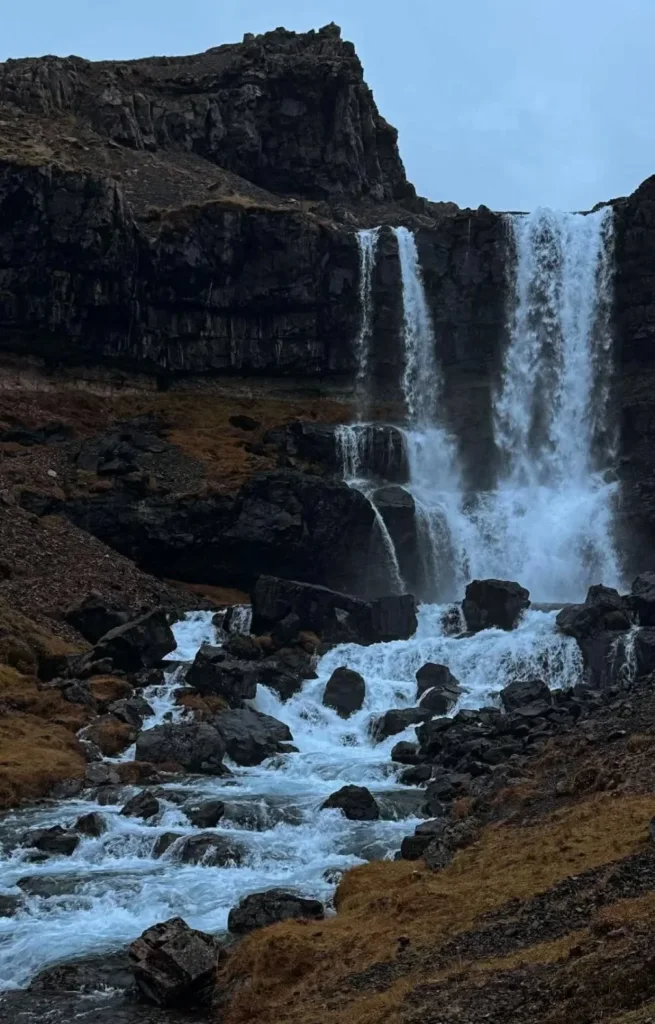 A waterfall between dark cliffs in October